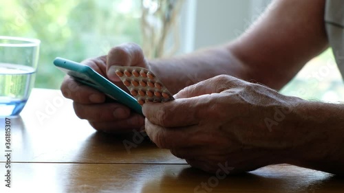 Senior man holding some pills and smartphone, close up. Ordering medicine online