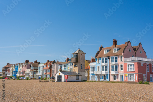 Stampa su Tela View of pastel coloured buildings on Crag Path facing Aldeburgh Beach on a sunny day with blue sky