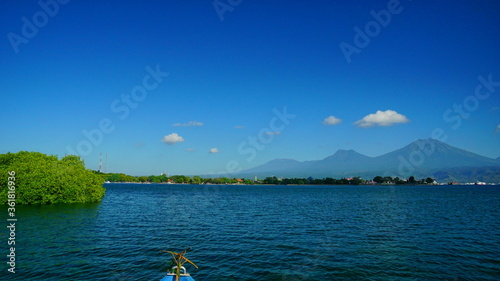 A view from Bali strait to Java island. Bali Strait is a stretch of water separating Java and Bali while connecting the Indian Ocean and the Bali Sea. 