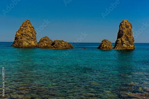 A group of Basalt Stacks offshore at Aci Trezza, Sicily in summer photo