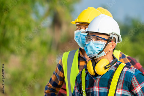 Solar power plant,Electrician wearing a medicine healthcare mask working and checking solar plant at solar power station,Climate change and renewable energy.