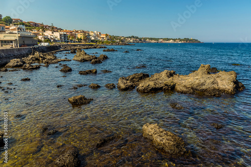 Basalt rocks jutting through a crystal clear sea at Aci Trezza, Sicily in summer