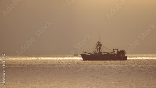 A Nostalgic Shrimp Boat Passing By On Calm Waters In The Morning Haze, establishing shot photo