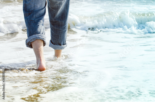 detail of man's legs and feet in sea water