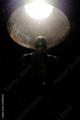 Abstract portrait of a man with a beard in the sun through a geometric window. Minimalism of the forms of light and shadow.