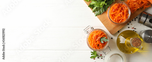 Composition with tasty carrot salad on white wooden background. Korean carrot