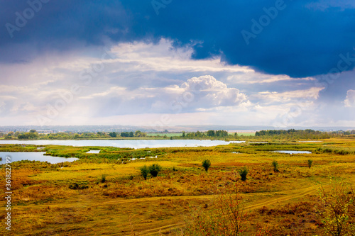Plain with lakes and blue sky with white clouds in autumn