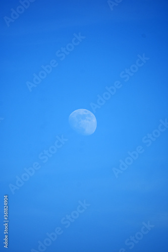 Moon in daylight on blue sky
