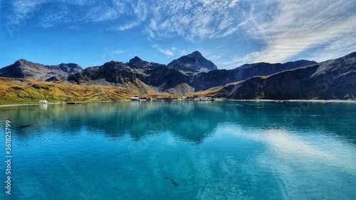 Dramatic landscape shot of Grytviken in South Georgia with blue skies and turquoise water