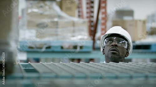 A industrial warehouse manager looks over inventory as it goes out for delivery. Shot in 4k. 