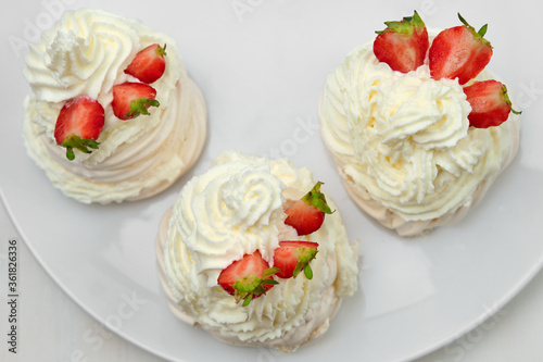 Meringue with strawberry and whipped cream on a white background. Homemade Anna Pavlova dessert. 