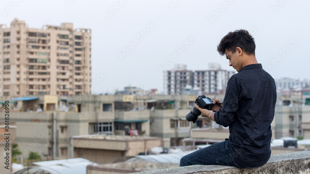 Young photographer clicking photographs at terrace during world pandemic. Solo Explorer.
