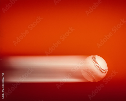 baseball in motion with motion streaks on a red background 