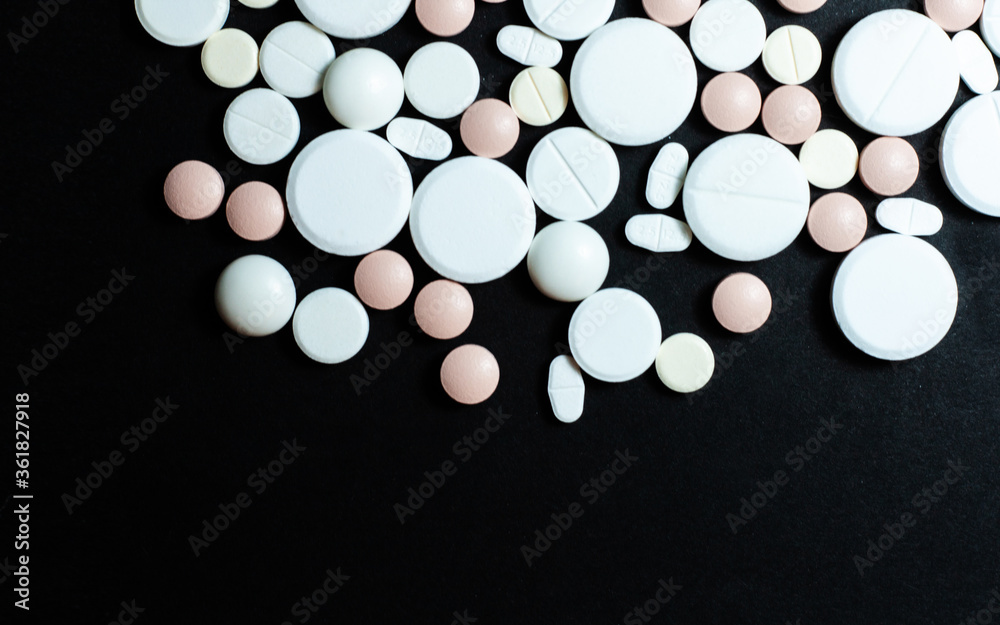 Heap of pills, tablets, capsules on black background. Drug prescription for treatment medication health care concept wth copy space background.