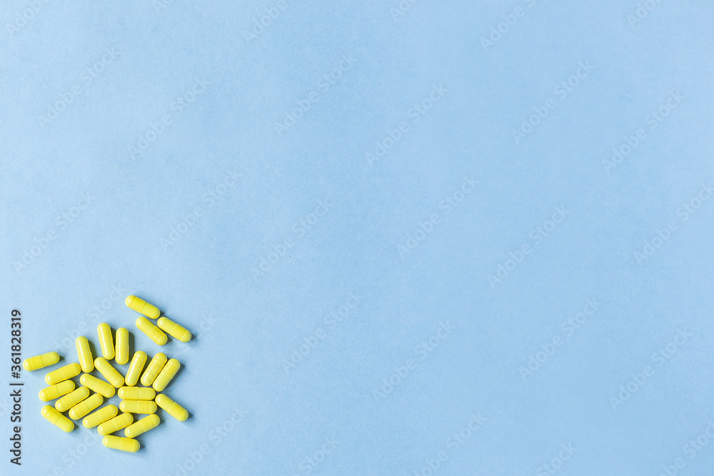 Yellow capsules on a blue background. Omega-3 vitamins. food Supplement. Fish oil in capsules. Free space. copy space. space for text. blurred background. Selective focus. banner. concept of medicine.