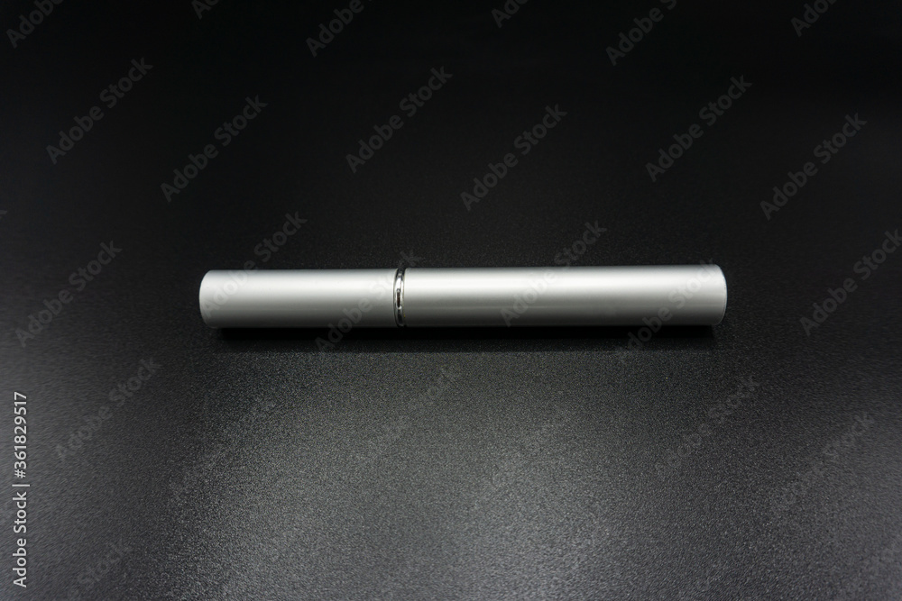Silver mascara tube, make up tool isolated on gray background Silver mascara tube, make up tool isolated on gray background