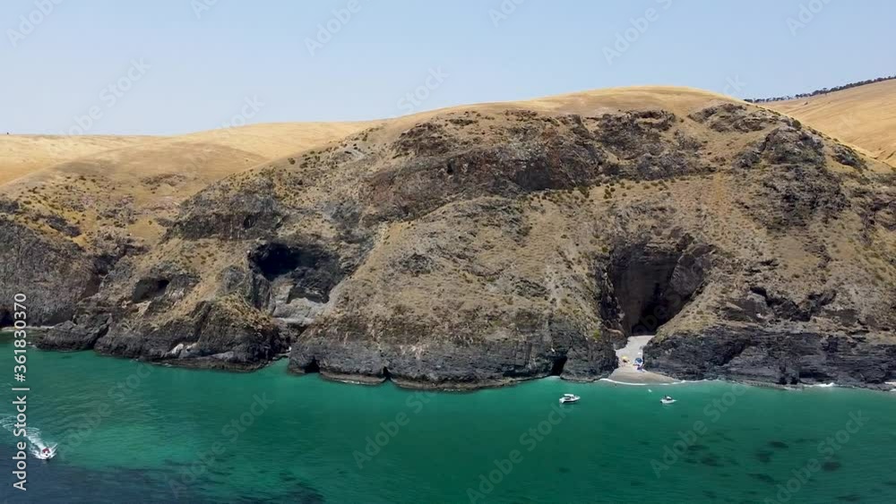 Boat Sailing And Leaving A Wake On The Blue Ocean By The Coastal Mountains In Rapid Bay, Fleurieu Peninsula, South Australia. - aerial drone Boat Sailing And Leaving A Wake On The Blue Ocean By The Coastal Mountains In Rapid Bay, Fleurieu Peninsula, South Australia. - aerial drone