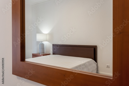 Modern stylish bedroom in the house  hotel  reflected in the mirror. Conceptual photo.