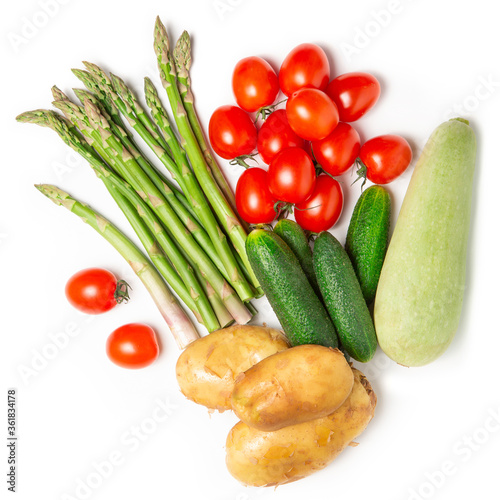 Fresh vegetables on a white isolated background. Crops. Asparagus, tomatoes, zucchini. Flat lay. The concept of proper nutrition.