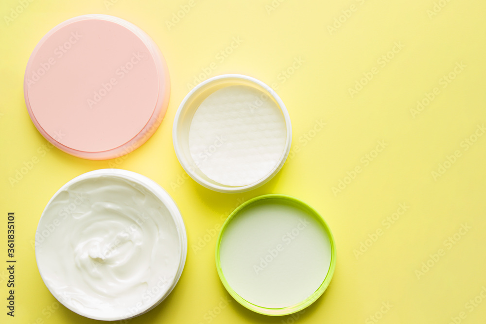Cosmetics and hygiene products for skin care. Set of face and body care products-top view, on a yellow background, beauty concept. Cosmetic cream for body care in a round package. Cosmetics and hygiene products for skin care. Set of face and body care products-top view, on a yellow background, beauty concept. Cosmetic cream for body care in a round package.