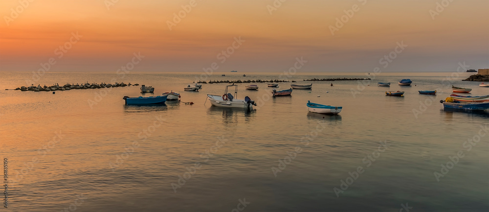 Fishing boats inside the calm of the breakwater at Aspra Sicily at sunset on a summer's evening Fishing boats inside the calm of the breakwater at Aspra Sicily at sunset on a summer's evening