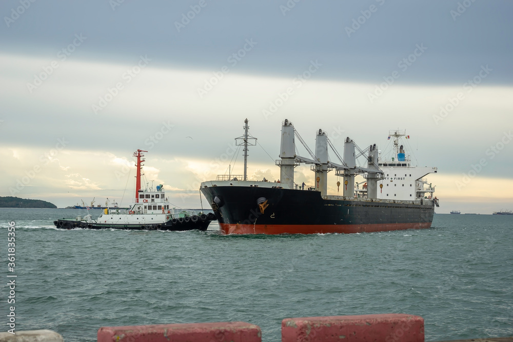 Small boats push large cargo vessels