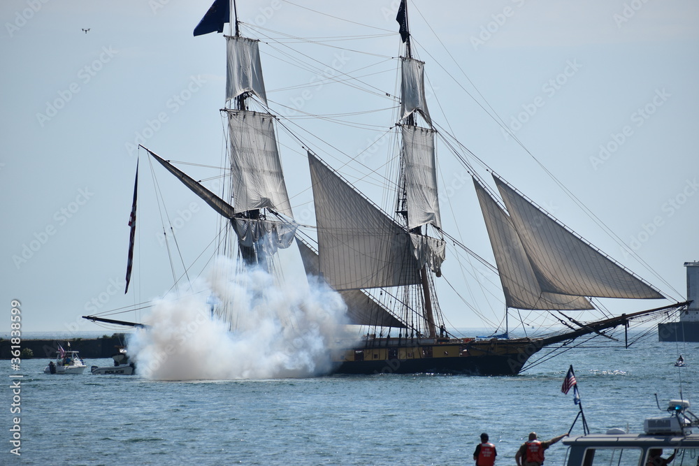 Obraz premium A tall ship shoots one of its cannons in a display