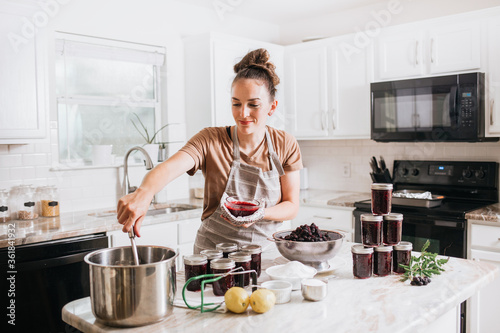 Vászonkép Woman canning homemade blackberry jam in home kitchen