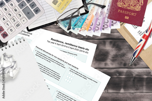 English Tax form sa108 Residence remittance basis etc from HM revenue and customs lies on table with office items. HMRC paperwork and tax paying process in United Kingdom photo