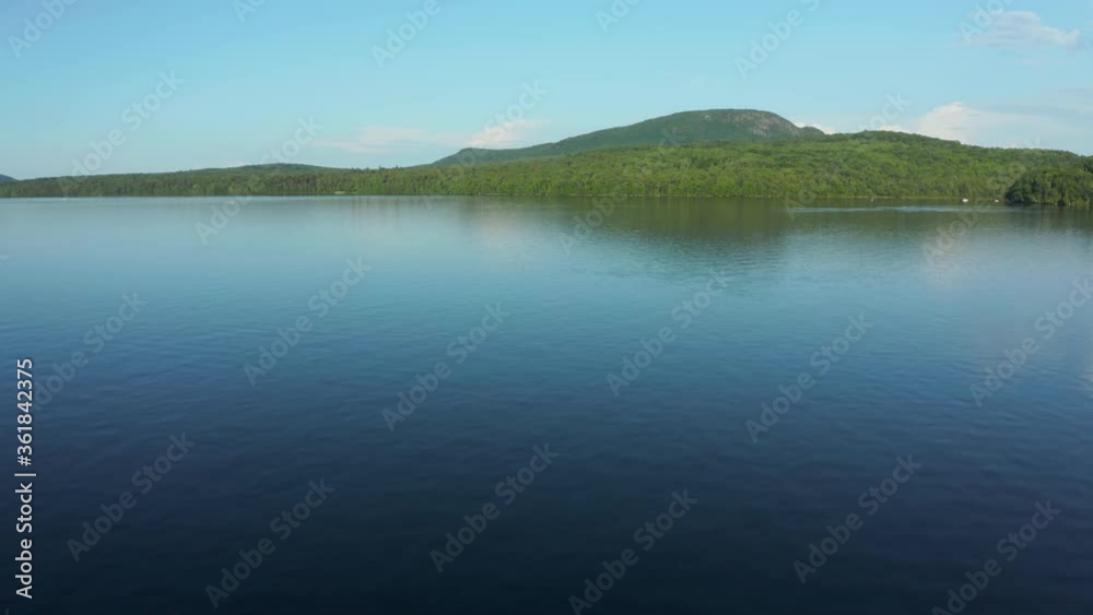 Drone going along the lake's water before flying up and away Drone going along the lake's water before flying up and away