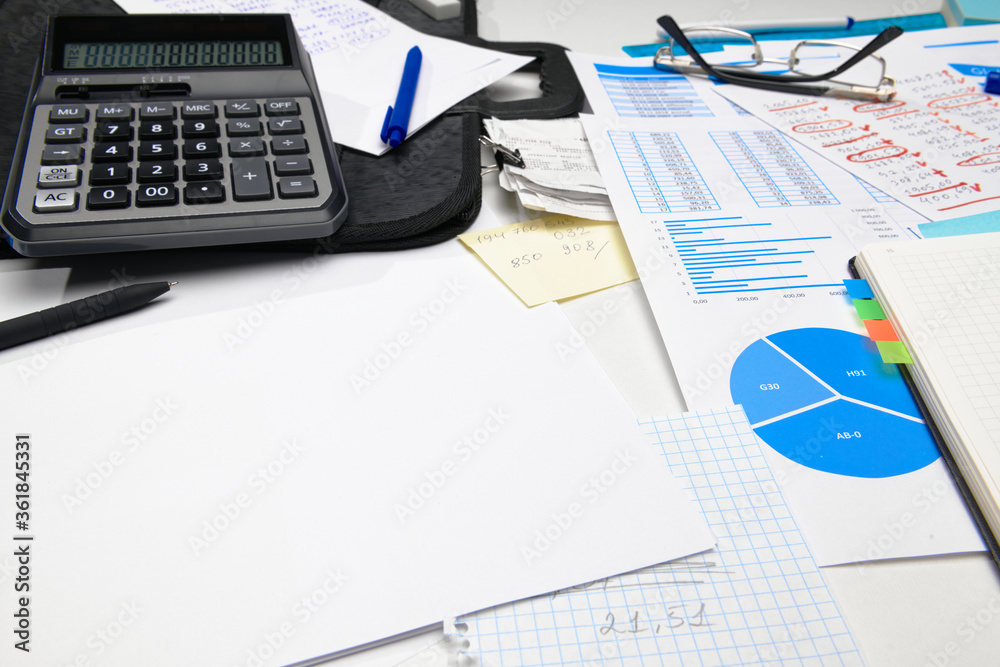 business office desk closeup - financial reports, analysis and accounting, set of documents, tables and graphs, various items for bookkeeping, calculator business office desk closeup - financial reports, analysis and accounting, set of documents, tables and graphs, various items for bookkeeping, calculator