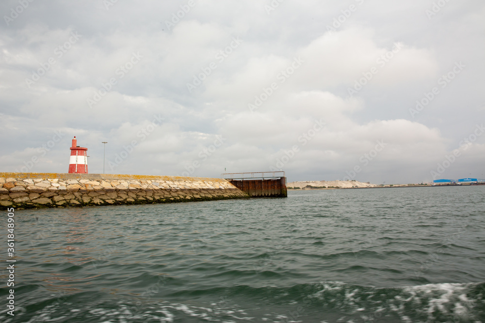 cloudy skies over light house at pier