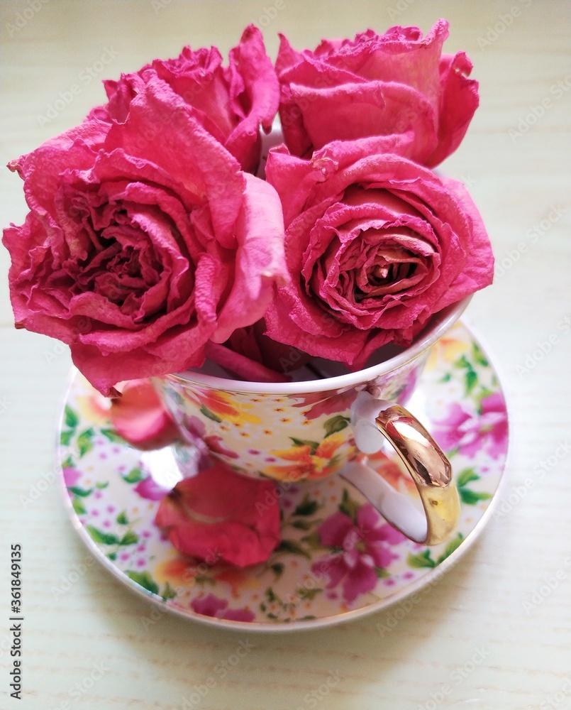 beautiful cup and saucer and dry pink roses