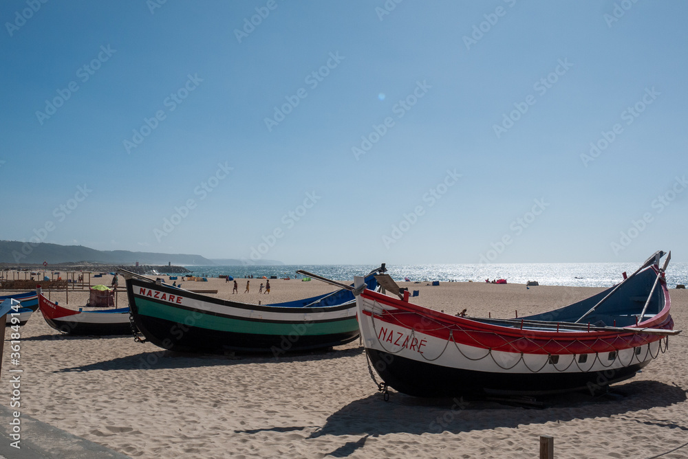 Two vintage fishing boats on the beach in Nazare Portugal