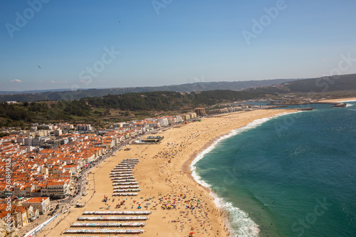 View of the beach ocean surf and town in Nazare Portugal © &Co Stock Images