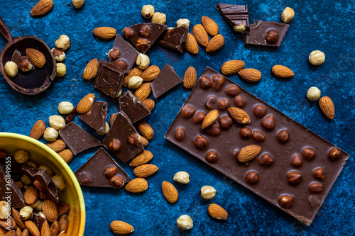 Chocolate chunks with hazelnuts isolated on blue background