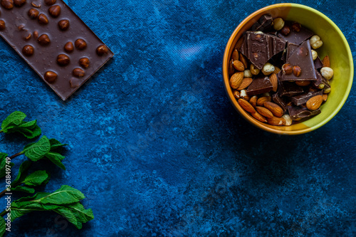 Chocolate chunks with hazelnuts isolated on blue background