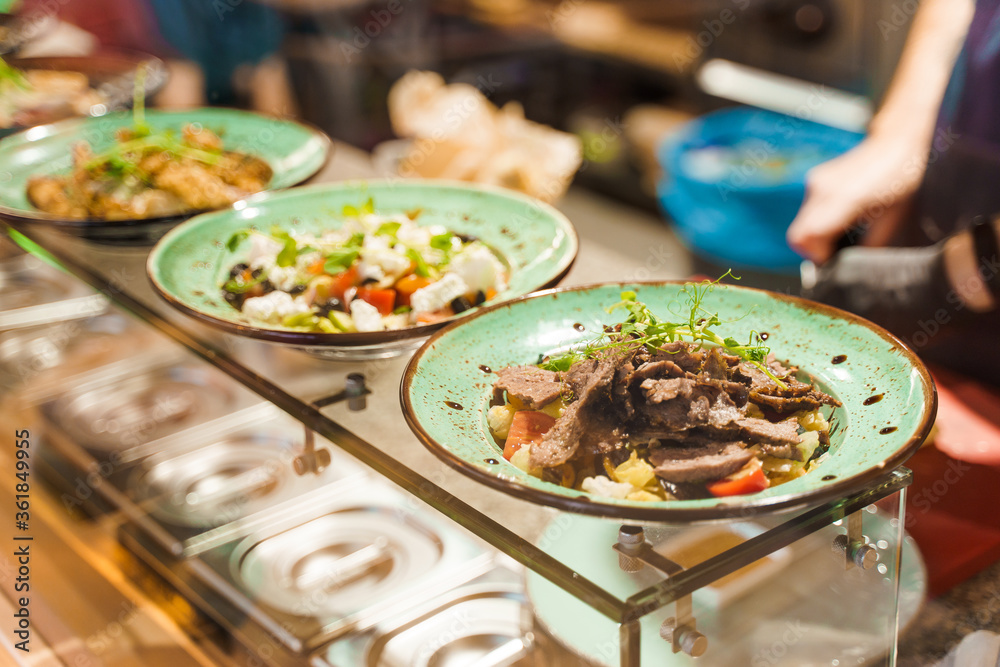 Salads in fast food restaurant according to social distance. Take away food in cafe in qarantine period. Healthy salads on the plates. Salads in fast food restaurant according to social distance. Take away food in cafe in qarantine period. Healthy salads on the plates.