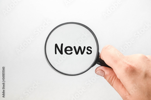 Word NEWS written in a magnifier on a white background.