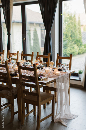 Beautiful stylish wedding with a beautiful decorated banquet table with fresh flowers. Wedding dinner. Served in a restaurant.