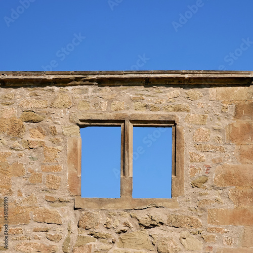 Brown window in a brick castle, blue sky. Germany.