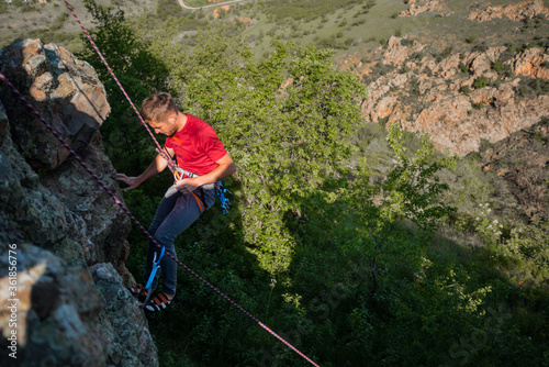 Rock climber climbing up a cliff