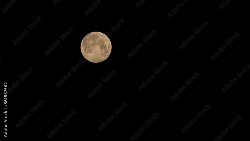 A Time-lapse video of penumbra lunar eclipse full moon shining bright in dark night sky observed through telescope A Time-lapse video of penumbra lunar eclipse full moon shining bright in dark night sky observed through telescope