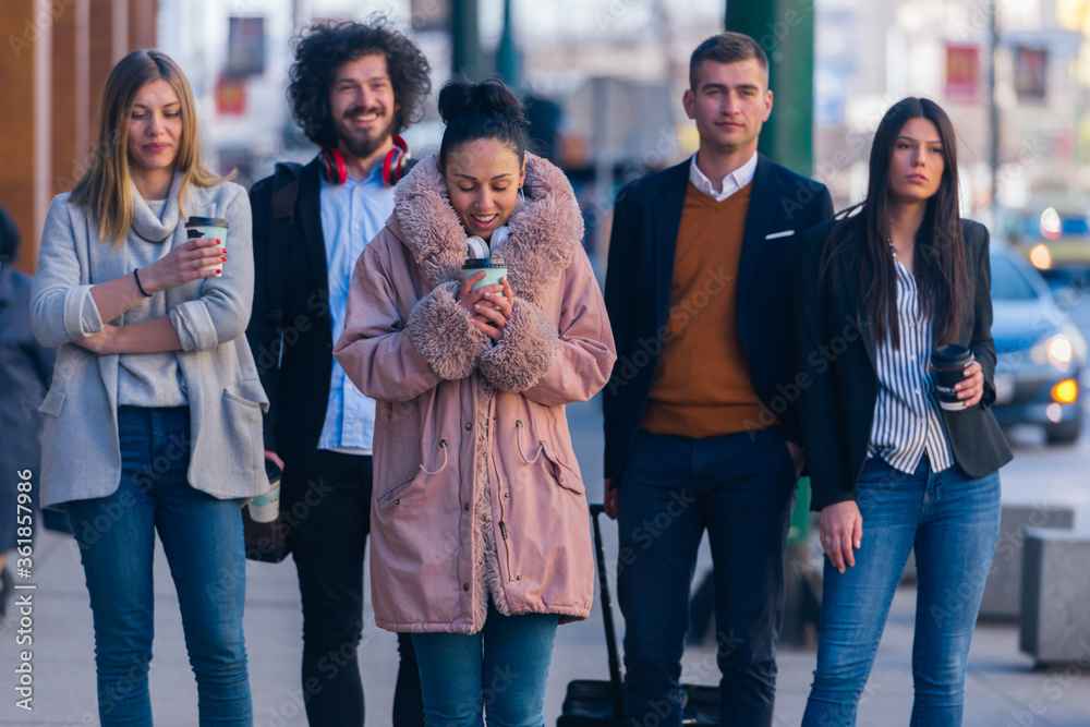 Fototapeta premium Group of diverse coworkers walking together, smiling and expressing a good vibe..