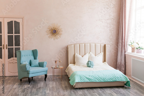 Real photo of a feminine bedroom interior with a comfy armchair  bed