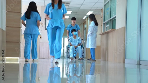 Doctors caregiver a patient in wheelchair Lobby area of Hospital.