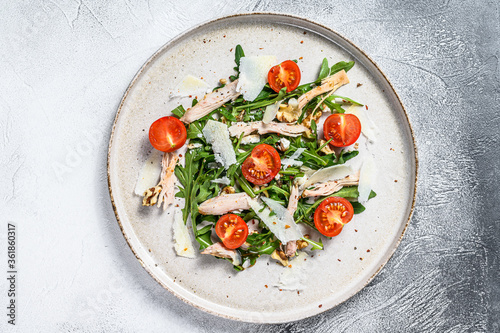 Salad with chicken, arugula, walnuts, tomatoes and Parmesan. gray background. Top view