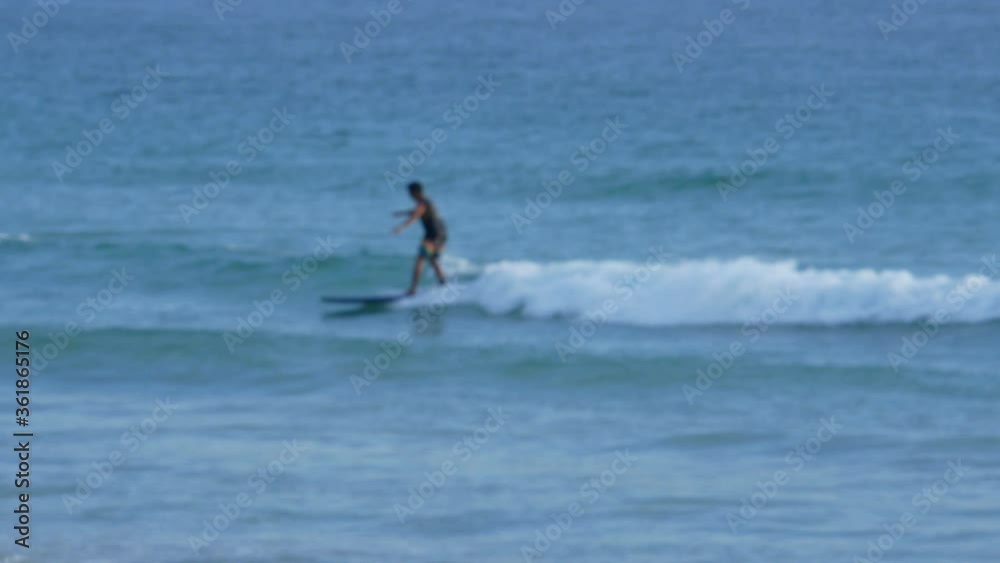 blur surfers with surfboard on the sea in sunny day blur surfers with surfboard on the sea in sunny day