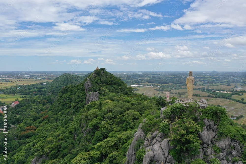 Fototapeta premium Buddhist statue rests above the mountain in Ratchaburi Thailand