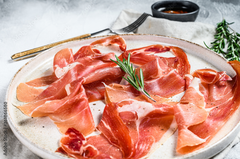 prosciutto crudo, italian salami, parma ham. Antipasto plate. Gray background, top view.
